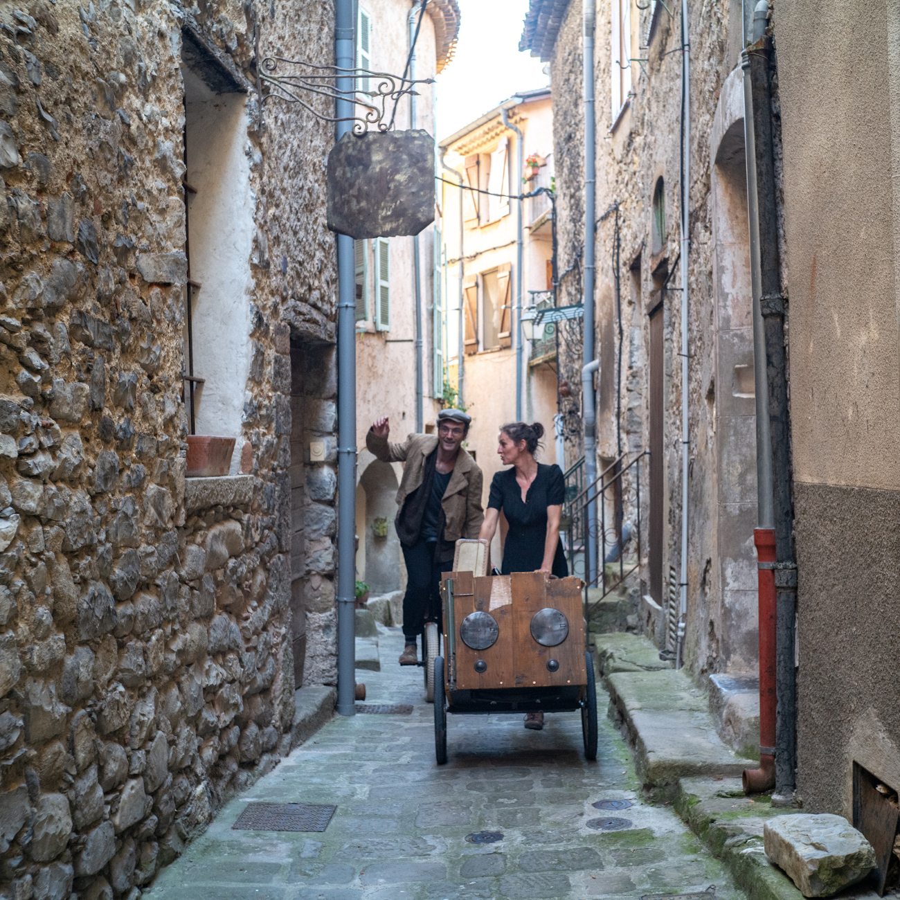 Les artistes se balladent dans une ruelle d'un village, en musique