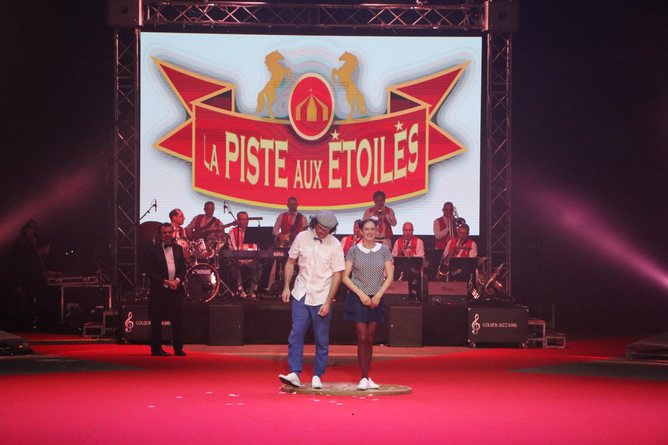 Salut avec les jongleurs et l'orchestre. en fond sur un ecran La piste aux étoiles