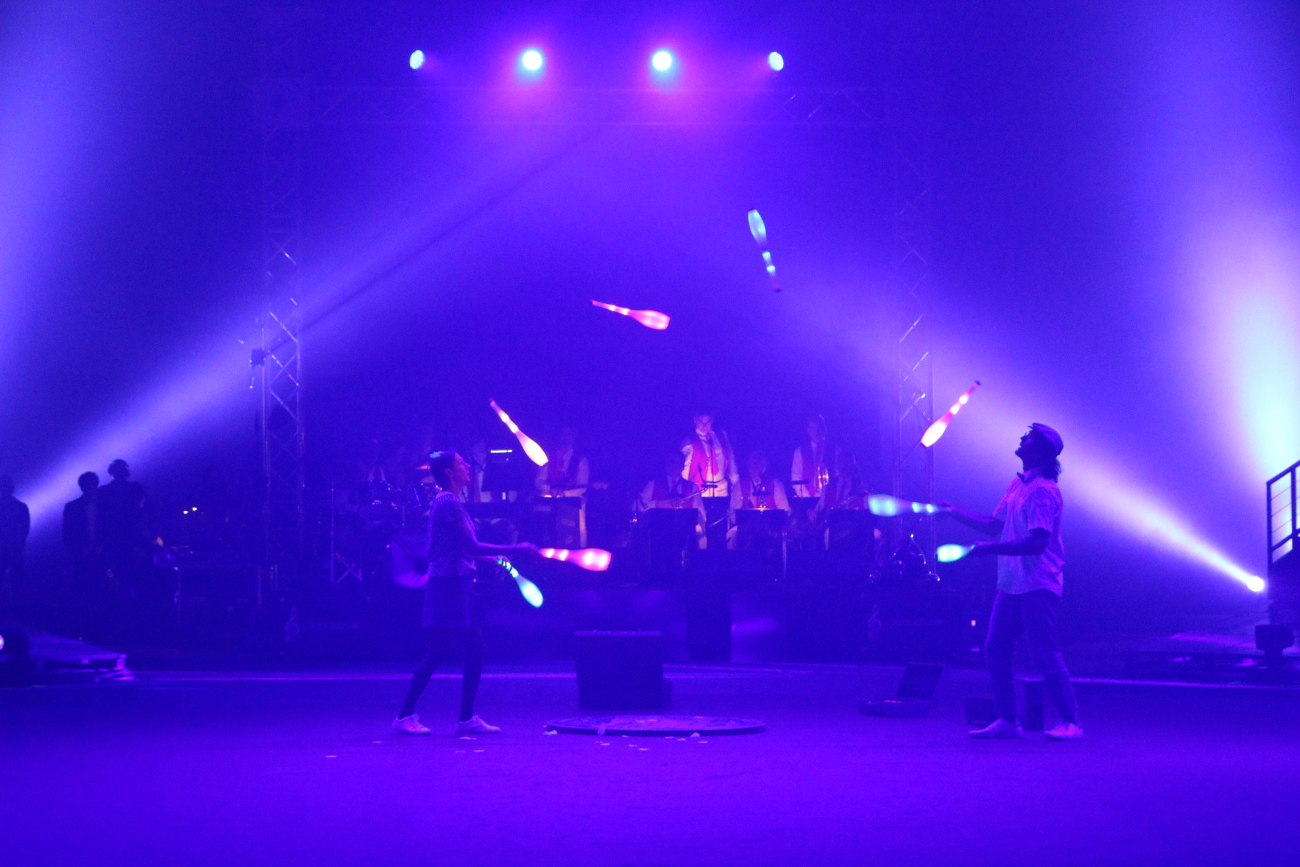 Passing avec 8 massues lumineuses sur la piste du cirque de Monaco. L'Orchestre en fond de piste