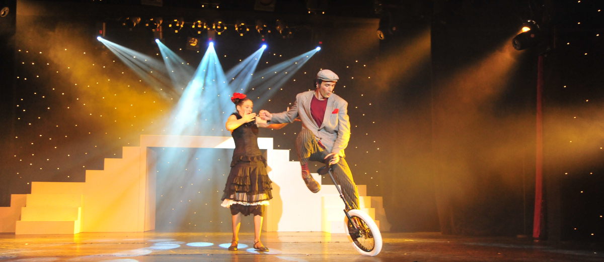 Gadjo & Gadji (jongleurs et equilibristes sur cycles) sur la scene d'un cabaret. Début de leur numéro visuel.