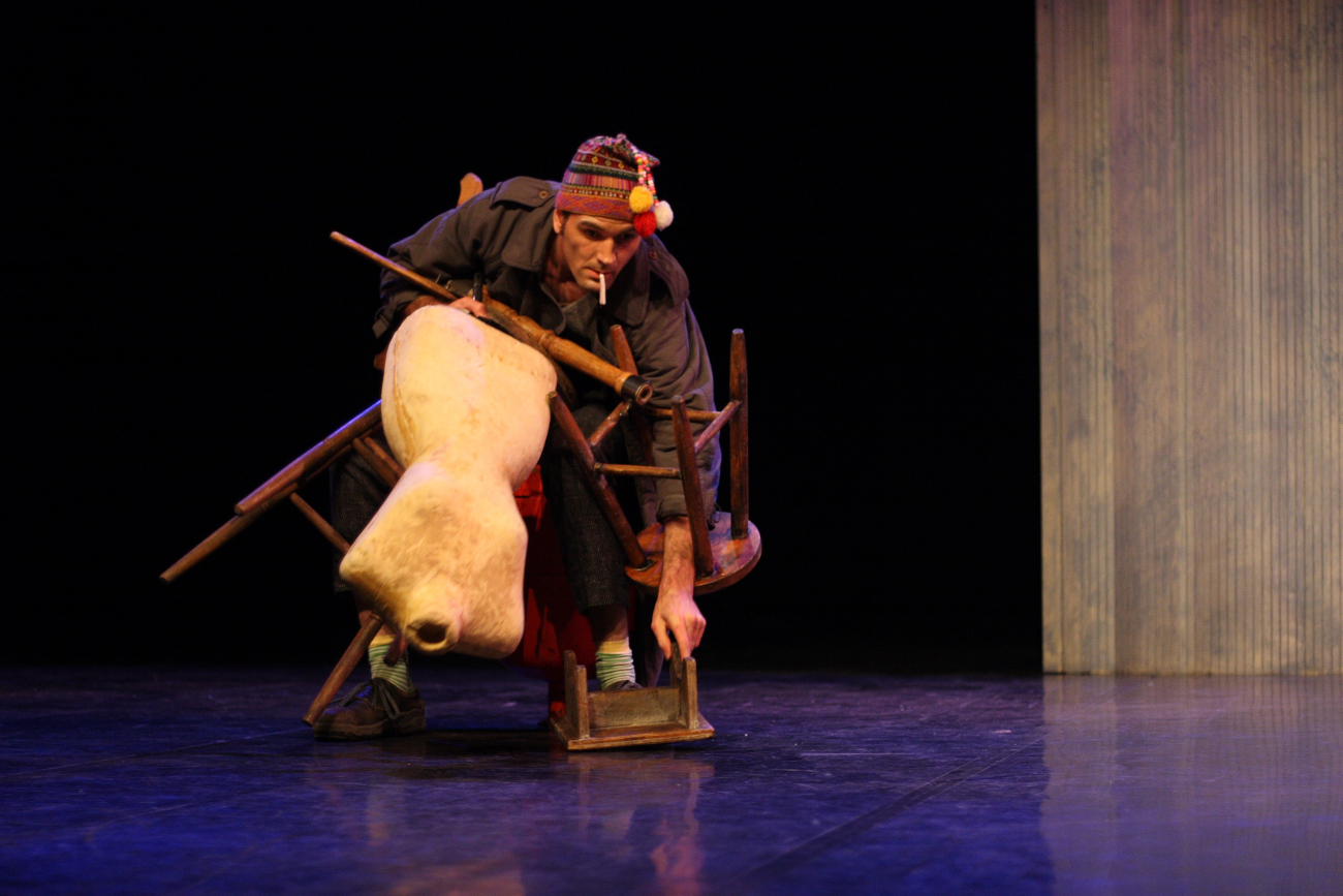 Un clown tres chargé ( 3 tabourets et un manequin de couture) sur la scene du theatre de la licorne à Cannes.