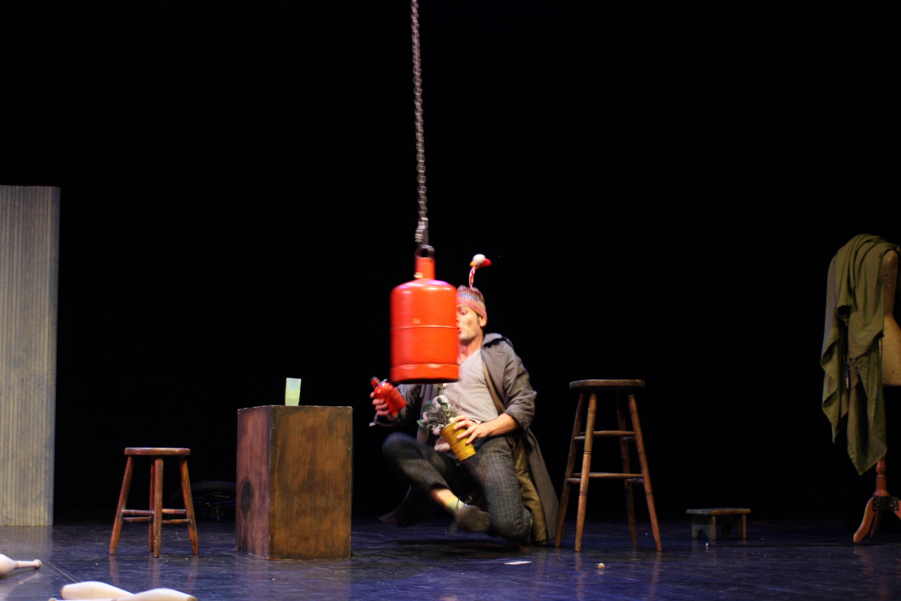 Numéro de clown perilleux avec une bouteille de gaz suspendu à une chaine.