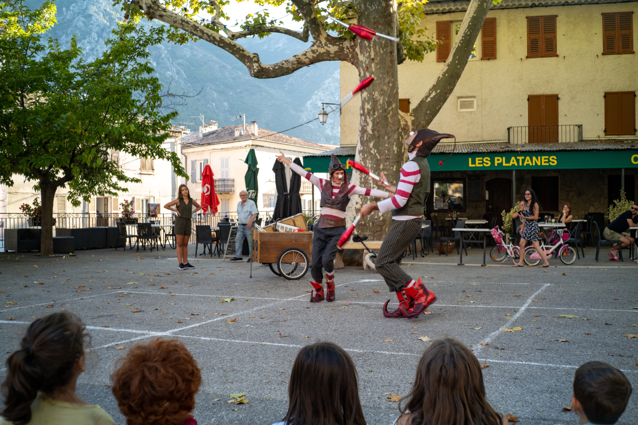 Sur une place à Villars, un spectacle improvisé par artistes de cirque habillés en Lutins de noel. ils jonglent avec 5 massues.