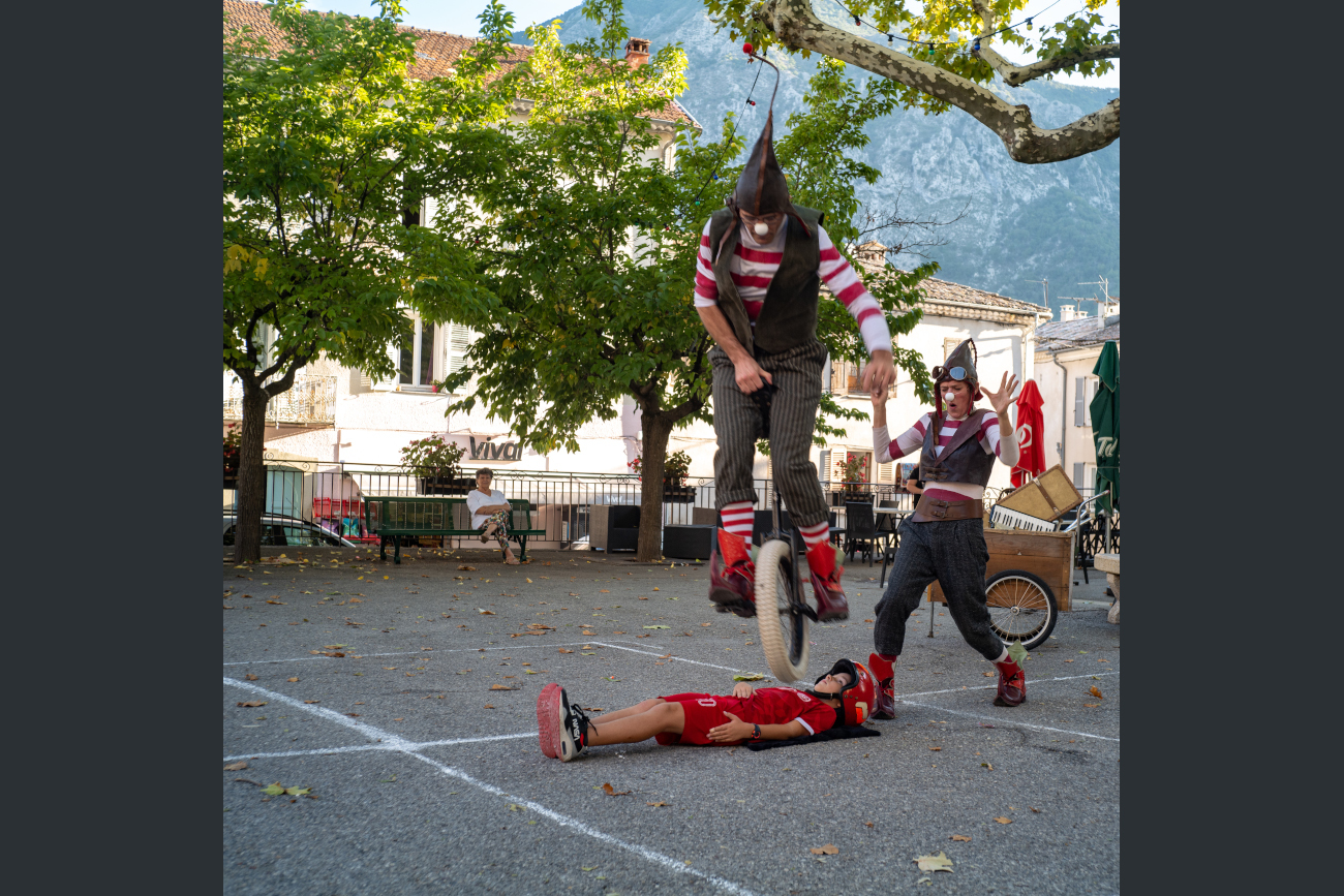 Spectacle de  rue des lutins avec interaction du public. Saut par dessus un enfant en monocycle